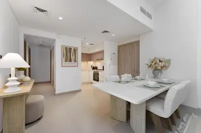 a white dining room with a white table and chairs at Your Exclusive Retreat in Dubai Hills by Suiteable in Dubai
