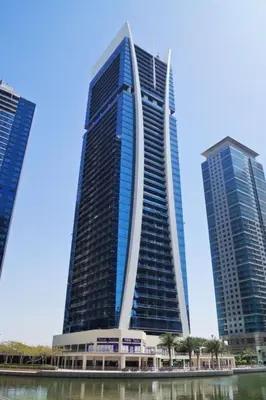 two tall buildings are next to a body of water at Click Stay - JLT - Studio & Balcony Lakes view Entire Apartment -RA in Dubai
