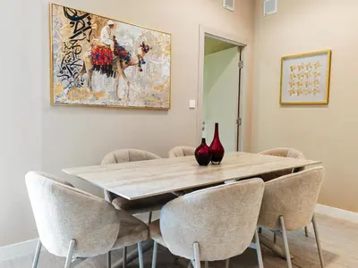 a dining room table with chairs and a painting on the wall at Modern, spacious, Luxe 5BR plus Maid condo in JBR, near JBR Beach, Marina view, By La Buena Vida Holiday Homes in Dubai
