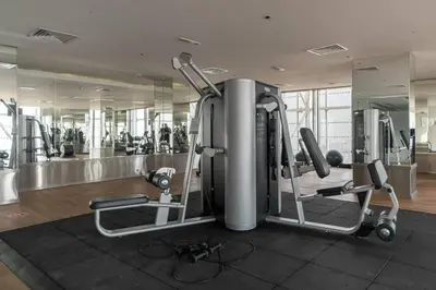 a gym with several treadmills and machines at StoneTree - Spacious Studio - The Matrix in Dubai