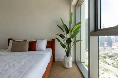 a bedroom with a bed and a potted plant at TH-Homes designed apartment Downtownview in Dubai