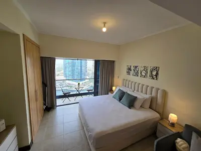 a bedroom with a large bed and a balcony at Click Stay - JLT - Entire Studio & Balcony Lakes view Apartment -NA in Dubai