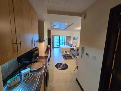 a kitchen and living room with a couch and a television at Click Stay - JLT - Entire Studio & Balcony Lakes view Apartment -NA in Dubai