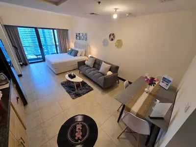 a living room with a couch and a table at Click Stay - JLT - Entire Studio & Balcony Lakes view Apartment -NA in Dubai