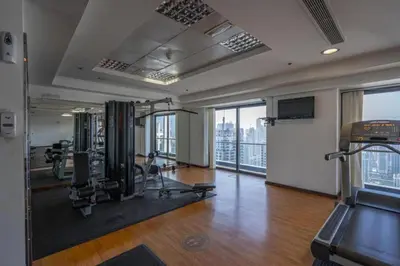 a gym with exercise equipment in a building with windows at Click Stay - JLT - Studio & Balcony Lakes view Entire Apartment -JN in Dubai