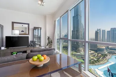 a living room with a couch and a large window at Incredible Fountain Views 2.5 BR Burj Residences in Dubai