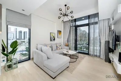 a living room with a couch and a table at Comfy 1BR in Azizi Riviera 8, Al Merkadh by Deluxe Holiday Homes in Dubai