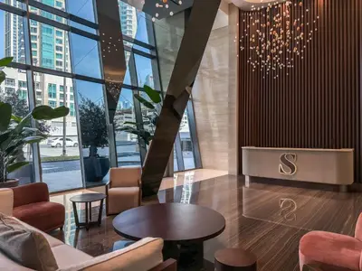 a lobby with a table and chairs and windows at Majestic 2BR Haven with Burj Khalifa View in Dubai