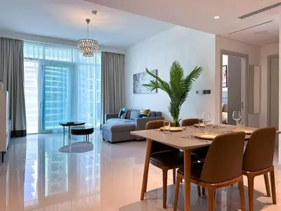 a dining room and living room with a table and chairs at Vibrant 1BR Apartment with Marina & Ocean View in Dubai