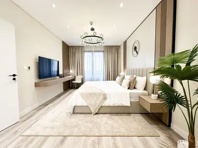 a bedroom with a large bed and a tv at Charming Ocean View 1BR Apartment at 5 Star Resort in Dubai