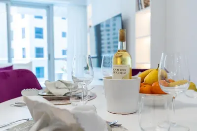 a bottle of wine sitting on a table with glasses at High class apartment in Dubai