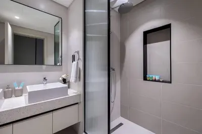 a white bathroom with a sink and a shower at Goldbest - 2bdr Marina view in Dubai
