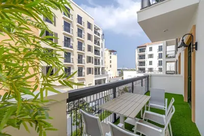 a balcony with a table and chairs on a building at Goldbest La Mer - Luxury 1 bdr Apartment with Beachfront Pool in Dubai