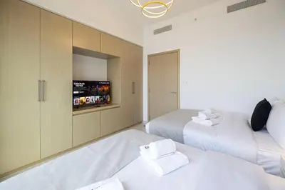 a bedroom with two beds and a flat screen tv at SmartStay at Burj Royale - Unique Downtown Dubai City Views - Brand New Luxury Apartments in Dubai