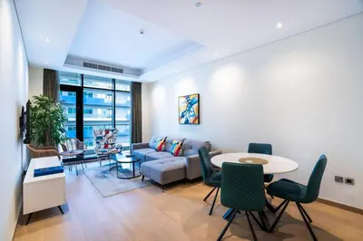 a living room with a couch and a table and chairs at RH - Burj Khalifa View, 01 BR Bliss at RP Heights, walk away to Dubai Mall in Dubai