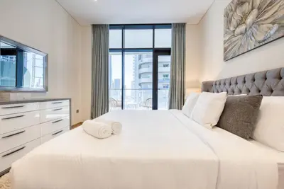 a bedroom with two white beds and a large window at RH - Burj Khalifa View, 01 BR Bliss at RP Heights, walk away to Dubai Mall in Dubai