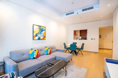 a living room with a blue couch and a table at RH - Burj Khalifa View, 01 BR Bliss at RP Heights, walk away to Dubai Mall in Dubai