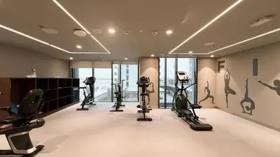a gym with treadmills and elliptical machines at Bright 2BR with Pool & Creek Views in Dubai