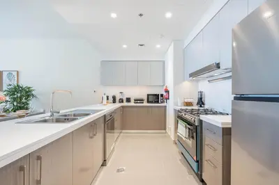 a kitchen with a sink and a refrigerator at Luxury 3BHK, Burj Khalifa & Dancing fountain view in Dubai
