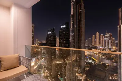a room with a view of a city at night at Luxury 3BHK, Burj Khalifa & Dancing fountain view in Dubai