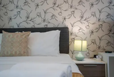 a bedroom with a bed and a wall with flowers at RH - Spacious studio, near Dubai Mall, Downtown in Dubai