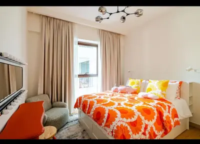 a bedroom with a bed and a chair and a window at Exquisite 1-Bedroom with Pool Scenery in Dubai Creek Harbour in Dubai