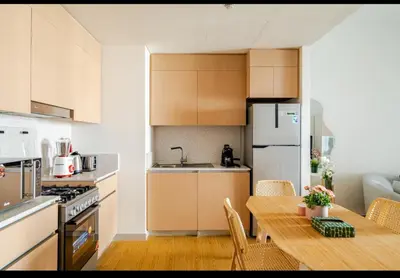 a kitchen with a table and a kitchen with a refrigerator at Exquisite 1-Bedroom with Pool Scenery in Dubai Creek Harbour in Dubai