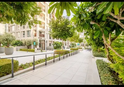 a walkway in a city with trees and buildings at Exquisite 1-Bedroom with Pool Scenery in Dubai Creek Harbour in Dubai