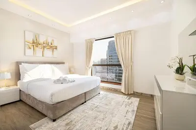 a white bedroom with a large bed and a window at Luxury 4-Bedroom with Maids Room, Marina and Ain Dubai Views in Dubai