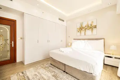 a white bedroom with a large bed with white sheets at Luxury 4-Bedroom with Maids Room, Marina and Ain Dubai Views in Dubai