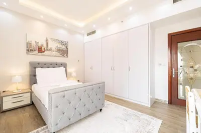 a white bedroom with a bed and a mirror at Luxury 4-Bedroom with Maids Room, Marina and Ain Dubai Views in Dubai