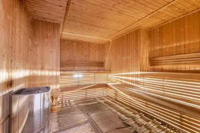 an empty wooden sauna with a trash can in it at Holiday Studio in JVC 2408, Dubai in Dubai