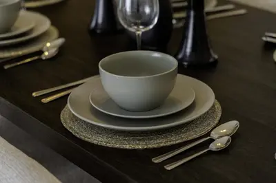 a wooden table with a cup and plates and spoons at Sleeps 8 Private Cinema World Island Views in Dubai