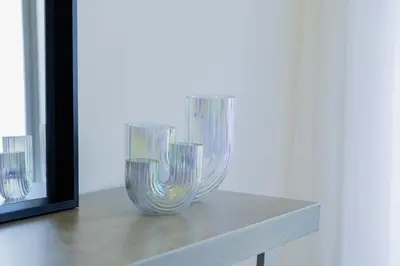two glass vases sitting on a table next to a mirror at Sleeps 8 Private Cinema World Island Views in Dubai