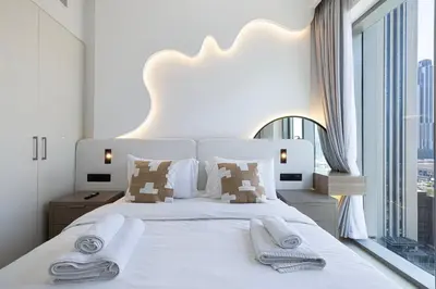 a bedroom with a white bed with towels on it at Burj Khalifa View & Dubai Mall Connection in Dubai