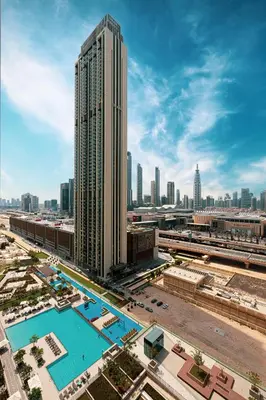 a large building with a pool in front of a city at Burj Khalifa View & Dubai Mall Connection in Dubai