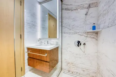 a bathroom with a shower with a sink and a mirror at RH - Beautiful & Spacious furnished 01 BR, Walk away from Dubai Mall in Dubai