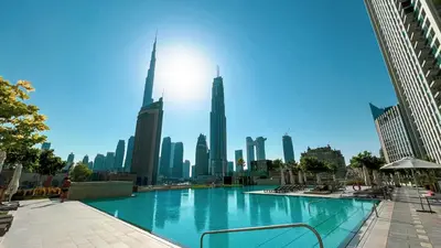 a large swimming pool in the middle of a city at FULL Burj Khalifa view 2BR with Dubai Mall connection in Downtown in Dubai