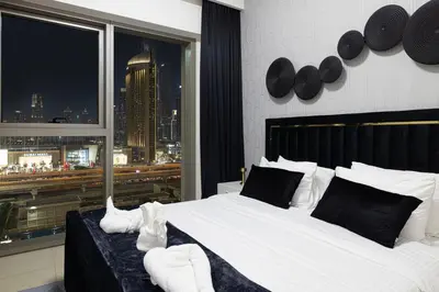 a bedroom with a large bed with a view of a city at FULL Burj Khalifa view 2BR with Dubai Mall connection in Downtown in Dubai