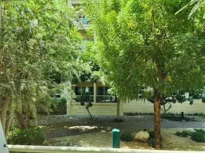 a building with a tree in front of it at quiet green 1 bedroom for your rest in Dubai
