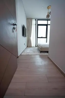 a hallway with a bedroom with a bed and a window at High Floor, 1 Bedroom in Palace Residence in Dubai