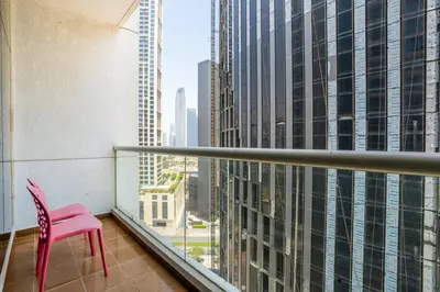 a pink chair on a balcony with a view of a city at RH - Best location, 01 BR Spacious, walk to burj in Dubai