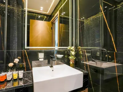 a bathroom with a white sink and a mirror at Stylish JVC 1 Bedroom Sanctuary in Dubai