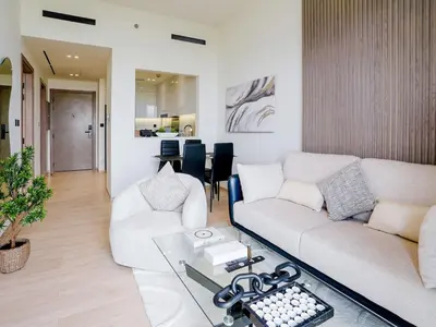 a living room with a couch and a table at Stylish JVC 1 Bedroom Sanctuary in Dubai