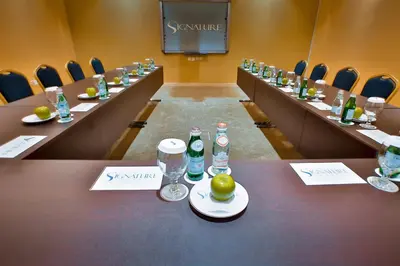 a conference room with long tables with bottles and glasses at Signature Hotel Al Barsha in Dubai