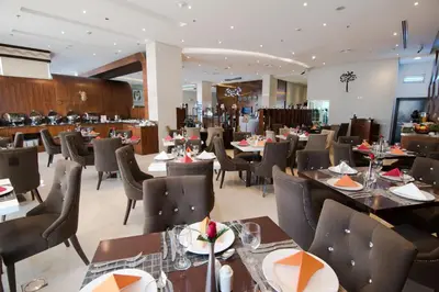 a dining room with tables and chairs in a restaurant at Signature Hotel Al Barsha in Dubai