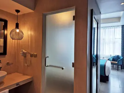 a bathroom with a door leading into a bathroom with a sink at Signature Hotel Al Barsha in Dubai