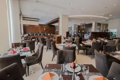 a restaurant with tables and chairs in a room at Signature Hotel Al Barsha in Dubai