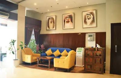 a waiting room with yellow chairs and a blue couch at Signature Hotel Al Barsha in Dubai