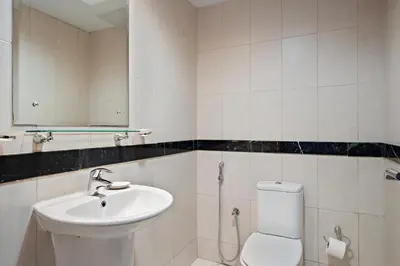 a bathroom with a sink and a toilet and a mirror at Silkhaus High Floor 1 BDR with Metro Nearby in Dubai